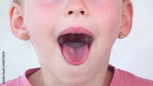 little girl show tongue, throat. child do gymnastics. kid Training of muscles speech therapy. Happy baby on white background. Place for text. portrait with wide open mouth and protruding tongue.