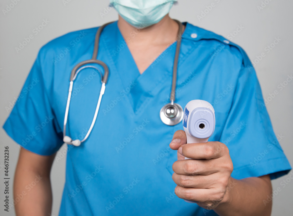 Close-up shot, Medical doctor use infrared forehead thermometer,thermometer gun to check body temperature for Coronavirus, virus symptoms - epidemic virus outbreak concept Close-up shot, Medical doctor use infrared forehead thermometer,thermometer gun to check body temperature for Coronavirus, virus symptoms - epidemic virus outbreak concept