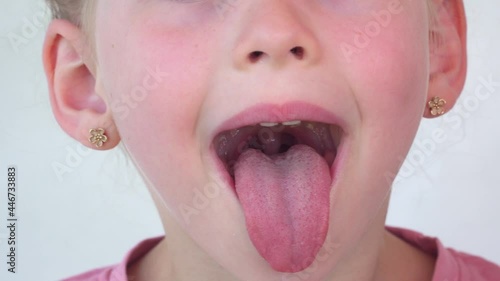 little girl show tongue, throat. child do gymnastics. kid Training of muscles speech therapy. Happy baby on white background. Place for text. portrait with wide open mouth and protruding tongue.