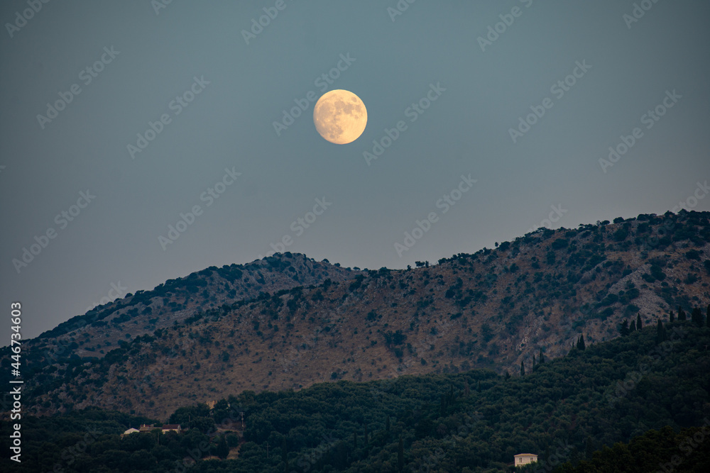 full moon over the mountains in corfu Greece
