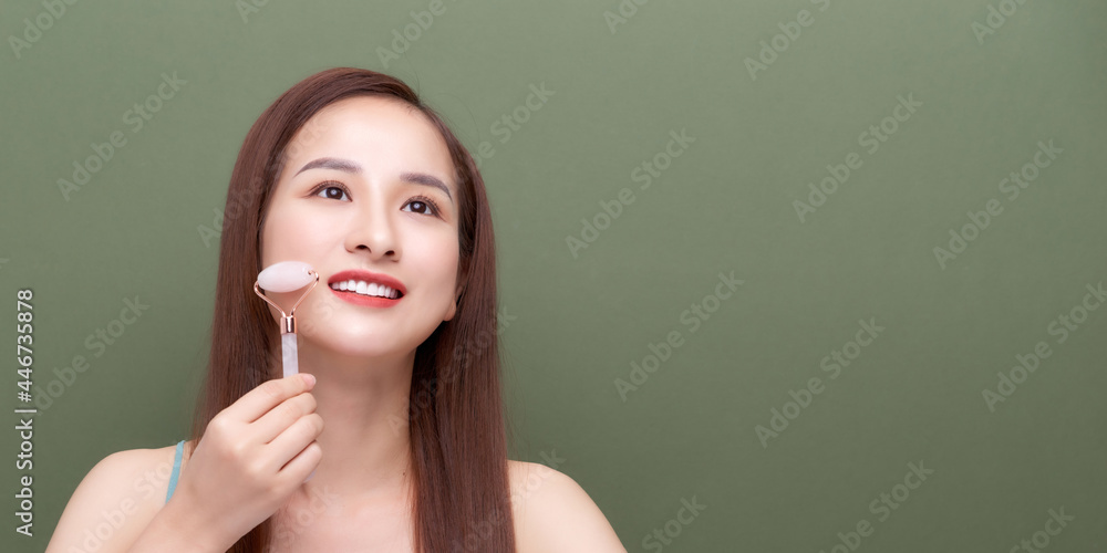Obraz premium Woman using face roller For Face Massage