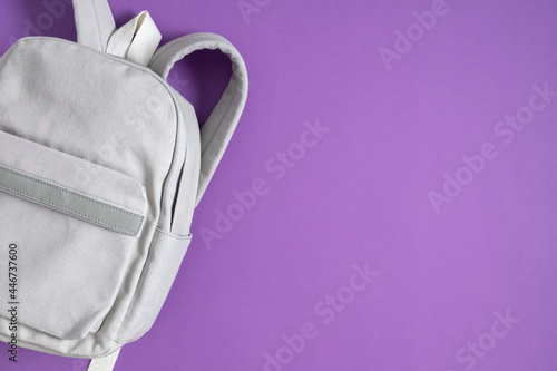 Backpack on purple background. Back to school. Flat lay, top view, copy space