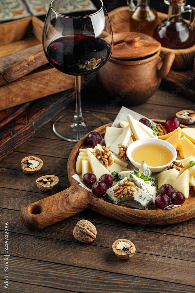 Cheese wine appetizer platter with grapes nuts and honey