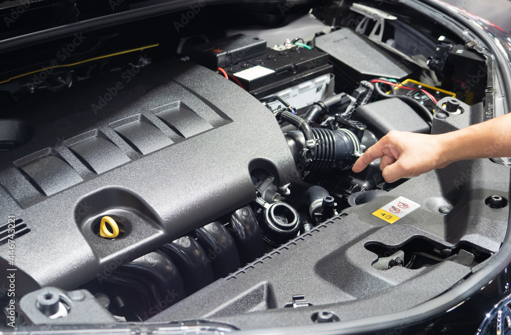Hand point finger at engine interior of new car Hand point finger at engine interior of new car