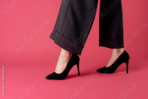 female feet black shoes cropped view pink background modern style glamor