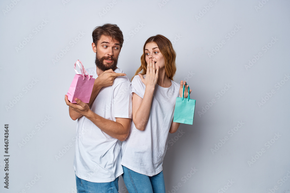 emotional men and women in t-shirts packages with gifts holiday light background emotional men and women in t-shirts packages with gifts holiday light background
