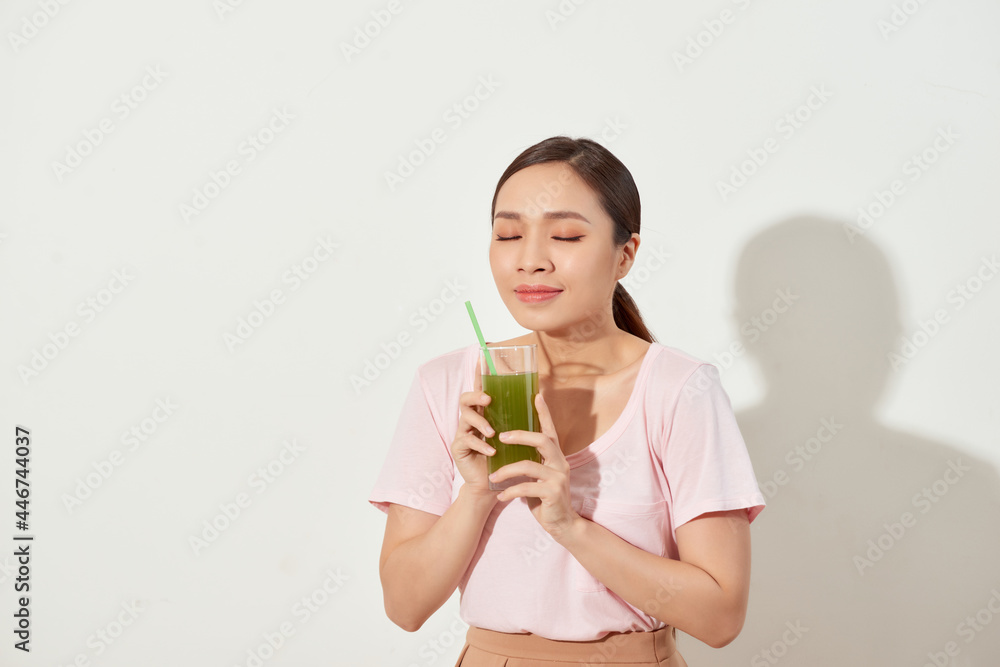 Young woman drinking green juice with straw Young woman drinking green juice with straw