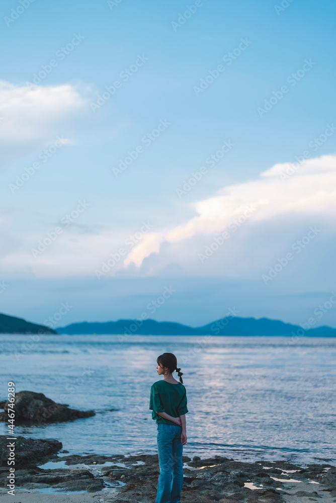 夕暮れの海にいる女性