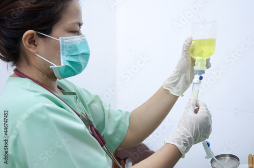 Nurse connecting an IV drip. Medical dortor provide intravenous fluid. photo