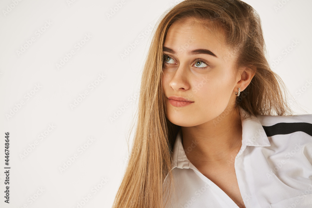 A girl in a white shirt stands on a white isolated background. A girl in a white shirt stands on a white isolated background.