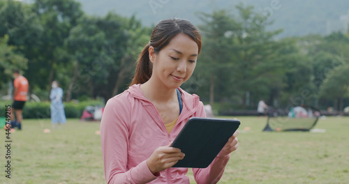 Woman use of tablet computer at park