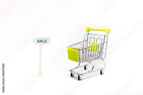 supermarket shopping trolley with direction road sign with message SALE 