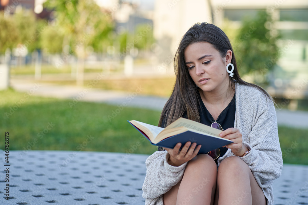 Obraz premium young women reading a book on the university campus. Education - culture concept