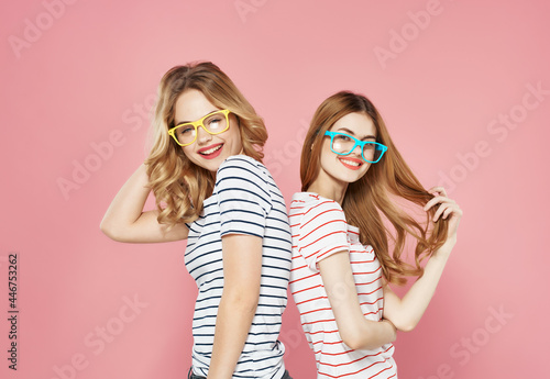 two cute girlfriends in colorful glasses striped t-shirts fashion fun