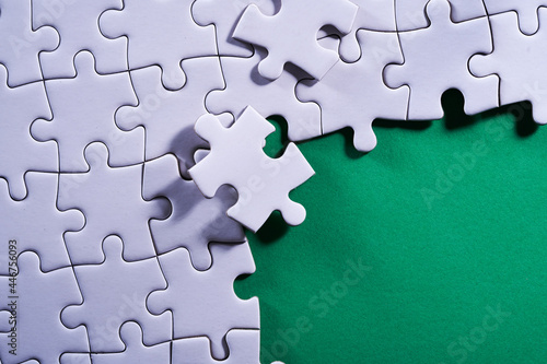 incompleted jigsaw puzzle on green background
