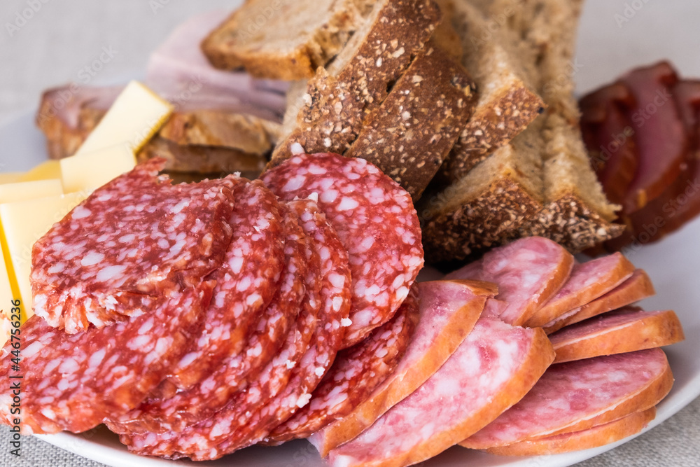 sliced smoked pork, bread, sausage, cheese on plate sliced smoked pork, bread, sausage, cheese on plate