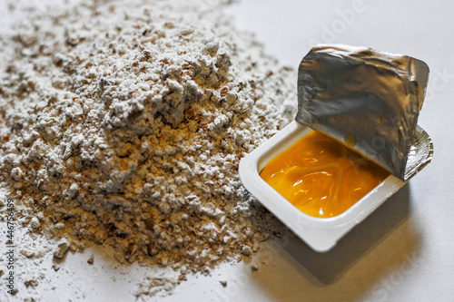 High angle shot of a small cap with fruit jelly and a handful of flour on a white surface photo