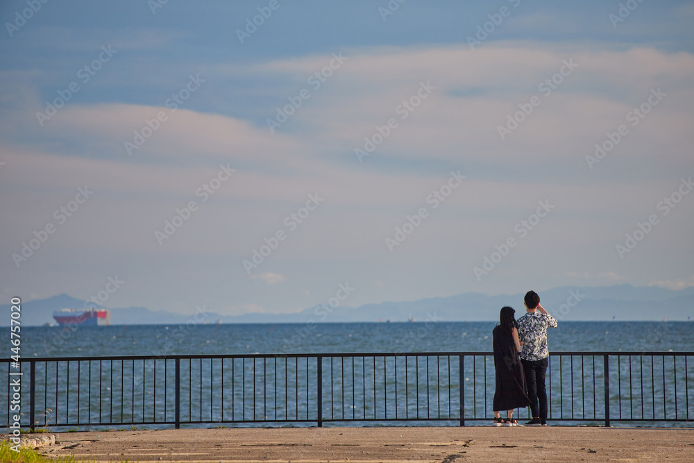 夏の海岸で散歩している若いカップルの姿