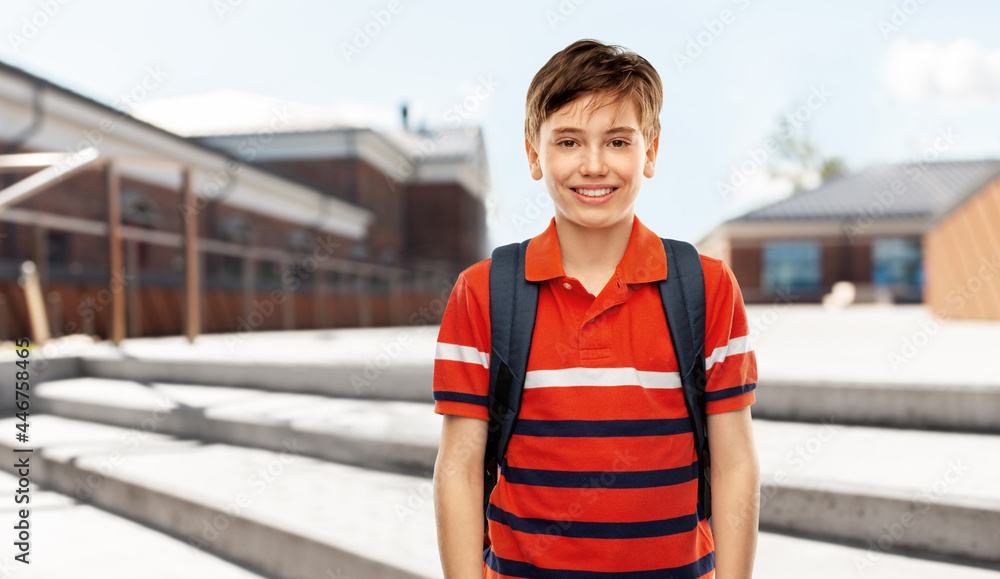school, education and people concept - smiling student boy with backpack over city street background