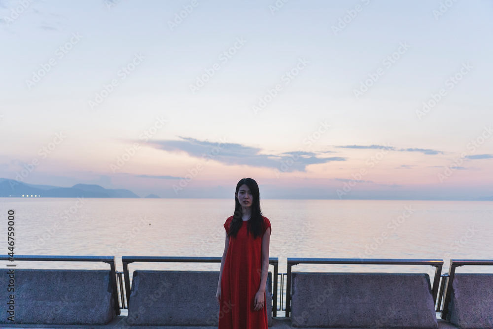 Fototapeta premium 夕暮れの海にいる女性