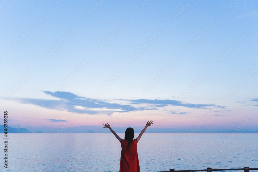 夕暮れの海にいる女性