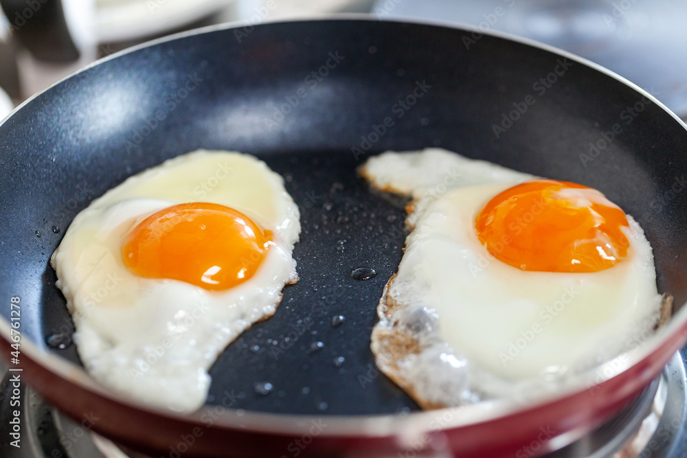 Breakfast getting ready. Sunny side fried eggs on the pan, closeup. Breakfast getting ready. Sunny side fried eggs on the pan, closeup.
