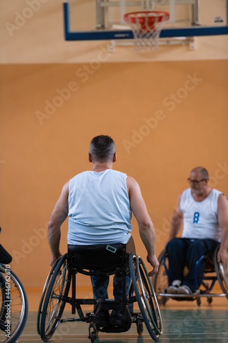 a war invalid in a wheelchair trains with a ball at a basketball club in training with professional sports equipment for the disabled. the concept of sport for people with disabilities