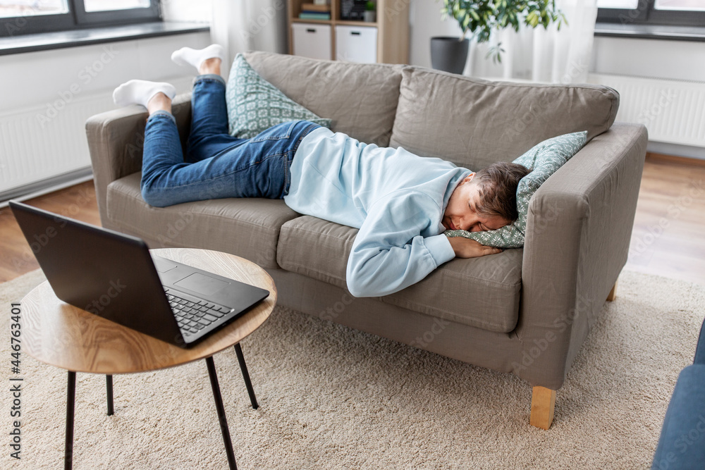 people, boredom and depression concept - bored or lazy young man with laptop computer lying on sofa at home people, boredom and depression concept - bored or lazy young man with laptop computer lying on sofa at home