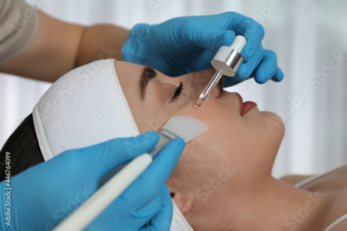 Young woman during face peeling procedure in salon  closeup