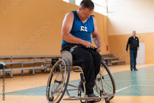 a photo of a war veteran playing basketball with a team in a modern sports arena. The concept of sport for people with disabilities © .shock