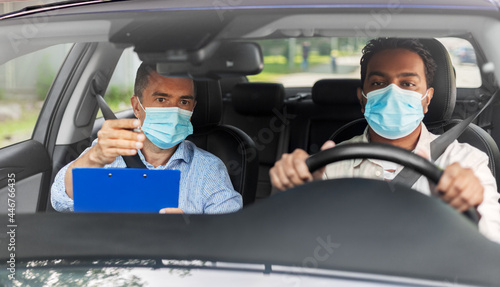 driver courses, health and people concept - young man and driving school instructor in mask with clipboard in car © Syda Productions