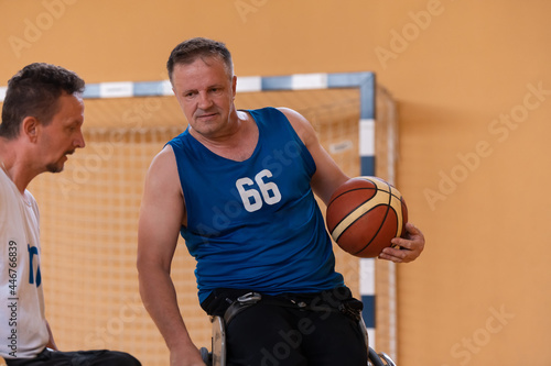 a photo of a war veteran playing basketball with a team in a modern sports arena. The concept of sport for people with disabilities © .shock