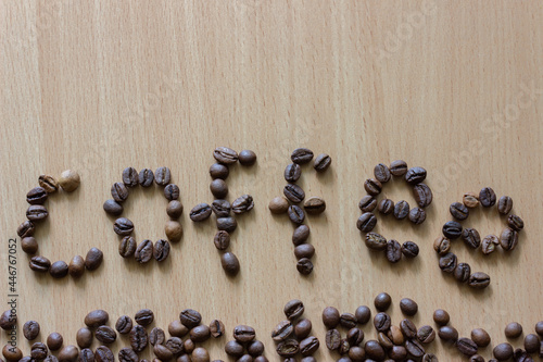 Coffee beans on wooden background. Word "coffee" from beans