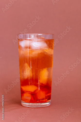 Wet glass with cold cocktail and ice inside, summertime drink
