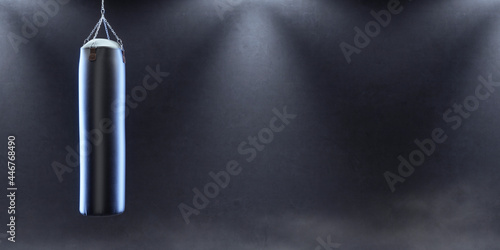 Punching bag with atmospheric studio light and empty space.