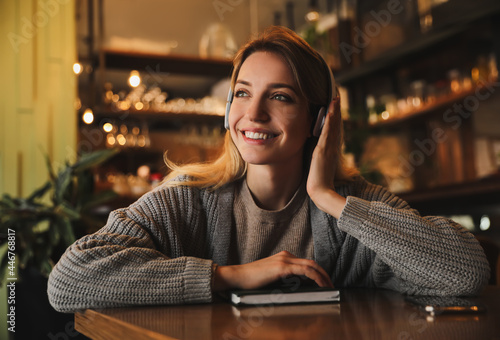 Woman listening to audiobook at table in cafe