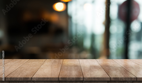 Empty wooden table top with lights bokeh on blur restaurant background.