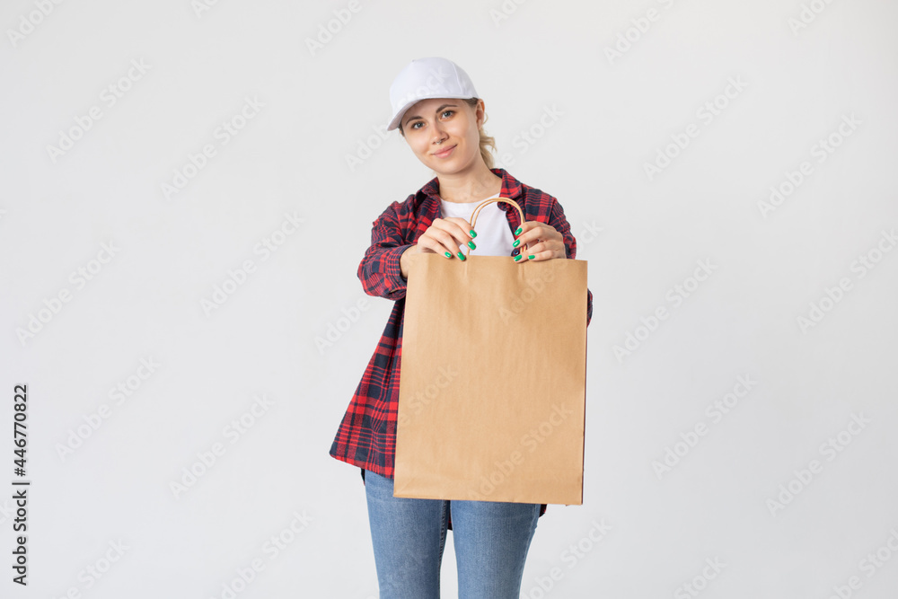 Smiling delivery woman holding paper bag with groceries. Smiling delivery woman holding paper bag with groceries.