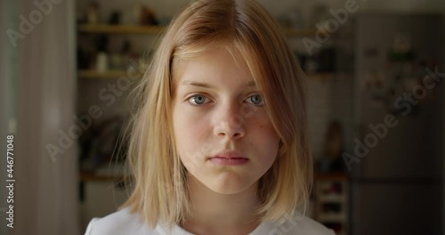 Portrait teenager Girl Looking at Camera Standing on home on Summer Day. Young Sad Thinking Curiosity Child Looking at Camera Closeup Outdoors. Face Eyes Serious Contemplative Child.