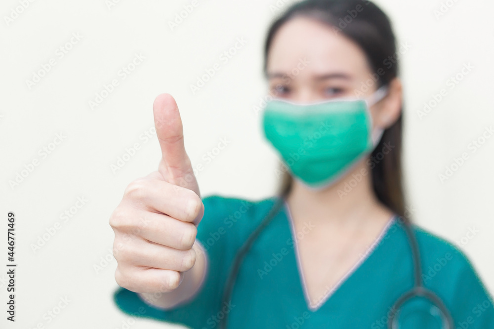 Asian woman wears green medical coat and medical face mask who shows thump up as good sign on white background. Asian woman wears green medical coat and medical face mask who shows thump up as good sign on white background.