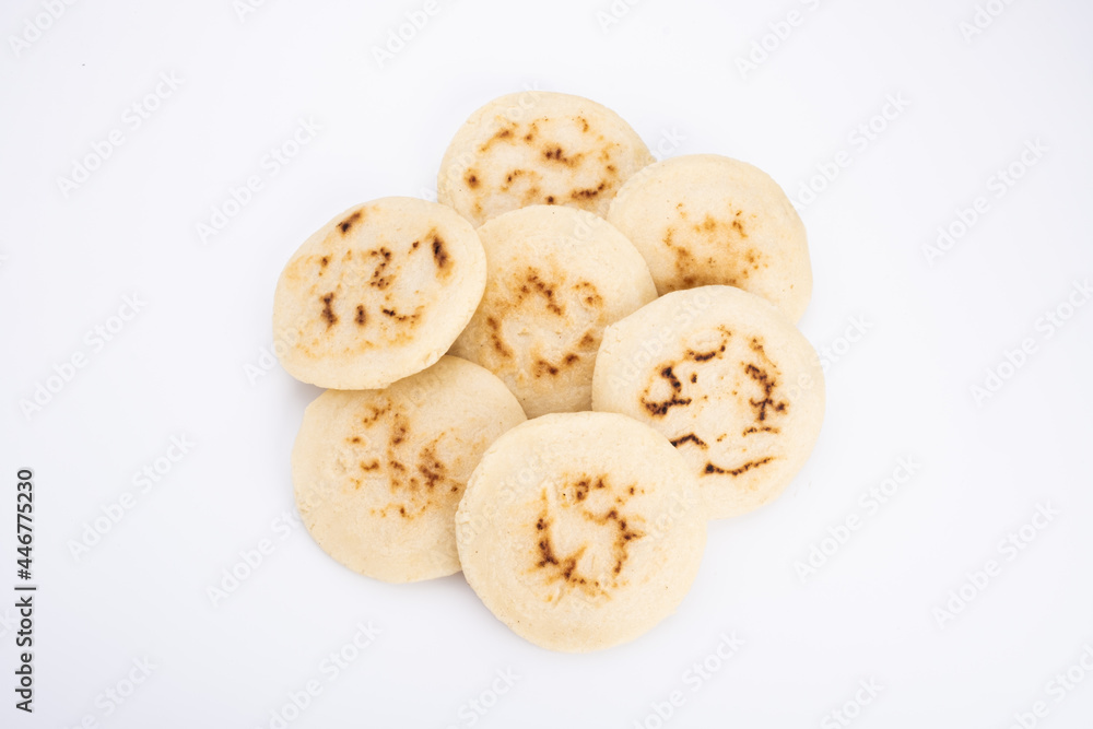 Stack of arepas made with corn flour on a white background, typical Latin American food. They are generally eaten in countries such as Venezuela Stack of arepas made with corn flour on a white background, typical Latin American food. They are generally eaten in countries such as Venezuela