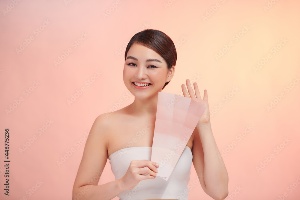 cute woman take skin color scale on the beige background