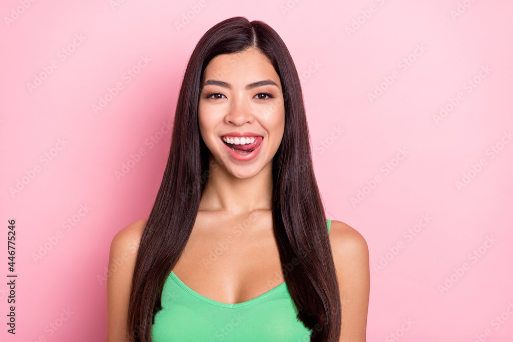 Photo of cute funny young lady wear green tank-top licking lips smiling isolated pink color background Photo of cute funny young lady wear green tank-top licking lips smiling isolated pink color background