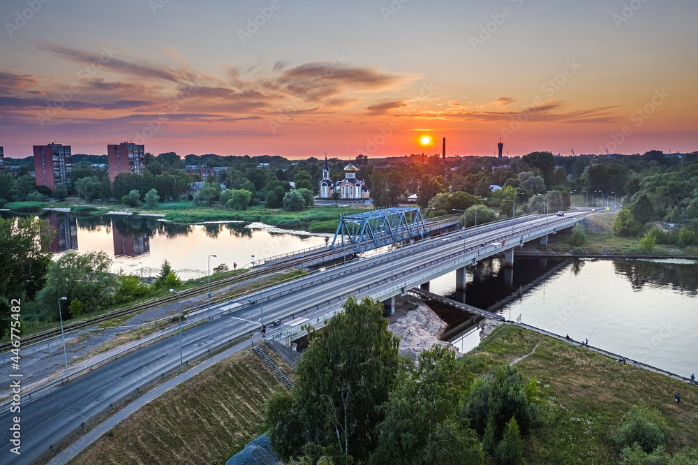 Riga port loading terminal with container ships. Boats and yachts riding on river. Industrial territory meets sustainable environment.

