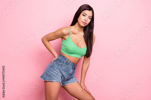 Photo of attractive cute young lady wear green tank-top standing smiling isolated pink color background