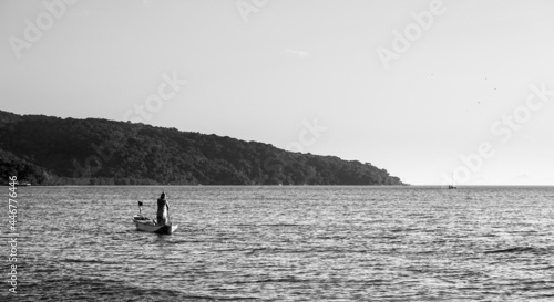 Black and white shot of a fisherman in Belo's beach on sunset - Ilha do Mel, Paraná, Brazil