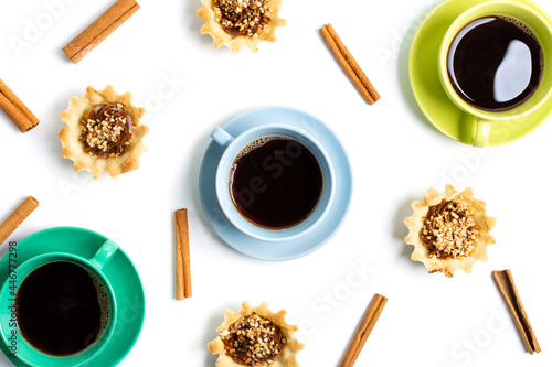 cups with coffee and fresh baked goods with nuts, dough on a white background