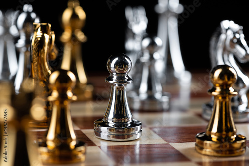 Gold and silver chess figures placed on chessboard