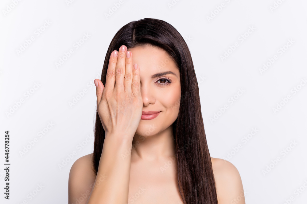 Photo of young woman happy positive smile close cover eye hand perfect fresh skin isolated over grey color background Photo of young woman happy positive smile close cover eye hand perfect fresh skin isolated over grey color background