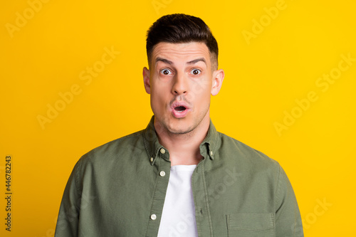 Photo of young guy amazed shock surprised omg wow fake news information isolated over yellow color background © deagreez